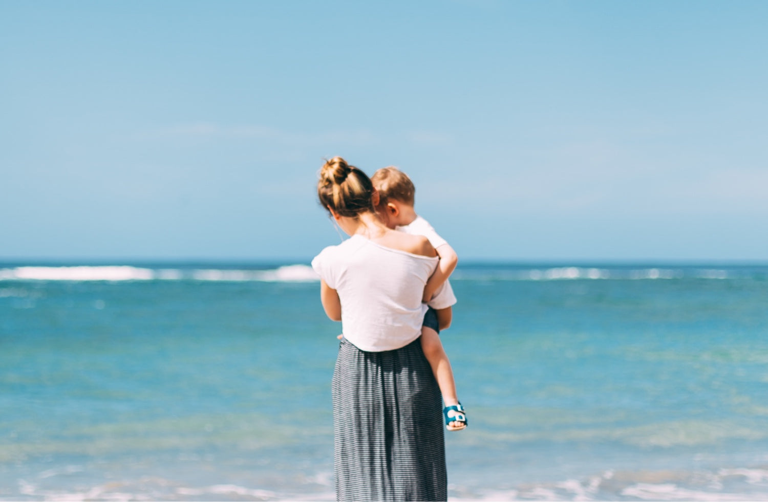 Mom holding son at beach